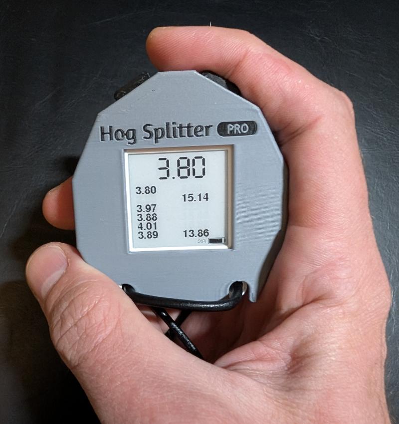 Hand holding Hog Splitter Pro with split times on the e-paper display